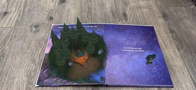 Animated .gif that shows a physical book in augmented reality with a 3d forest popping out of the book.